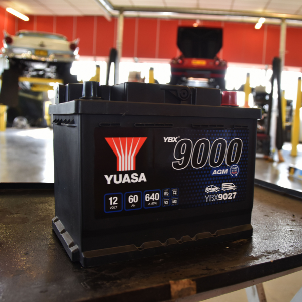 Yuasa battery on a workbench in a garage setting
